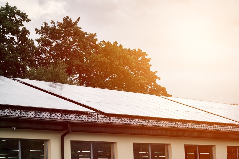 Solar array on roof with trees in the background sky