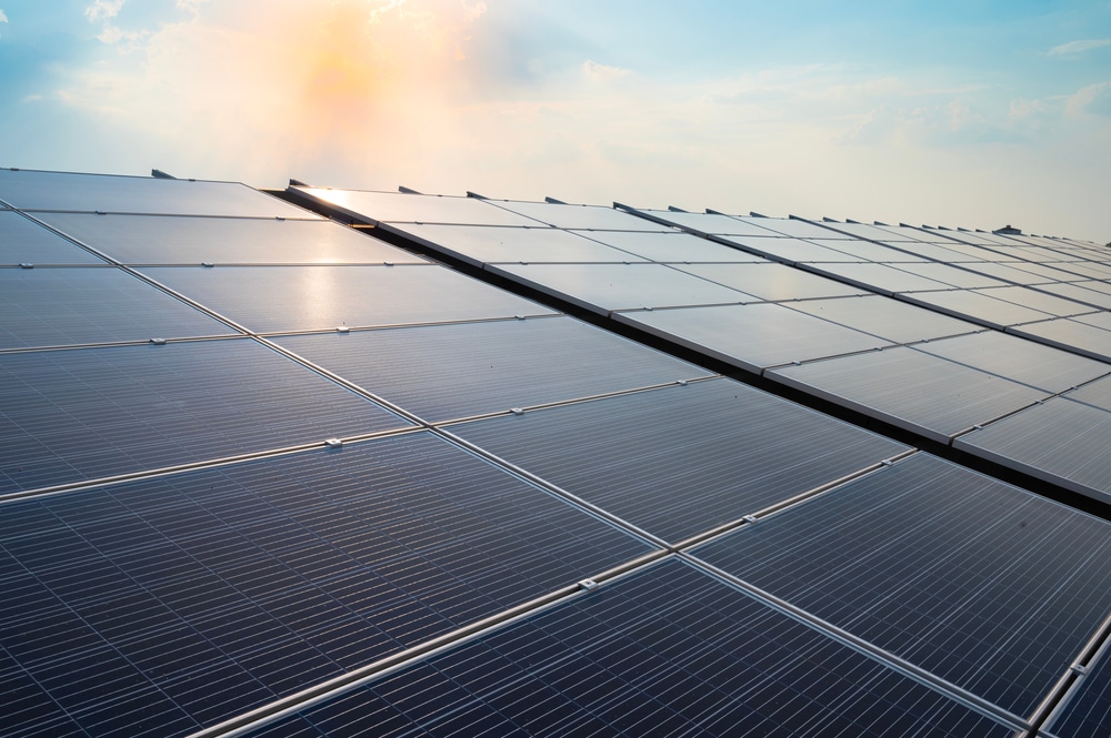 Solar array with sunshine in the background sky