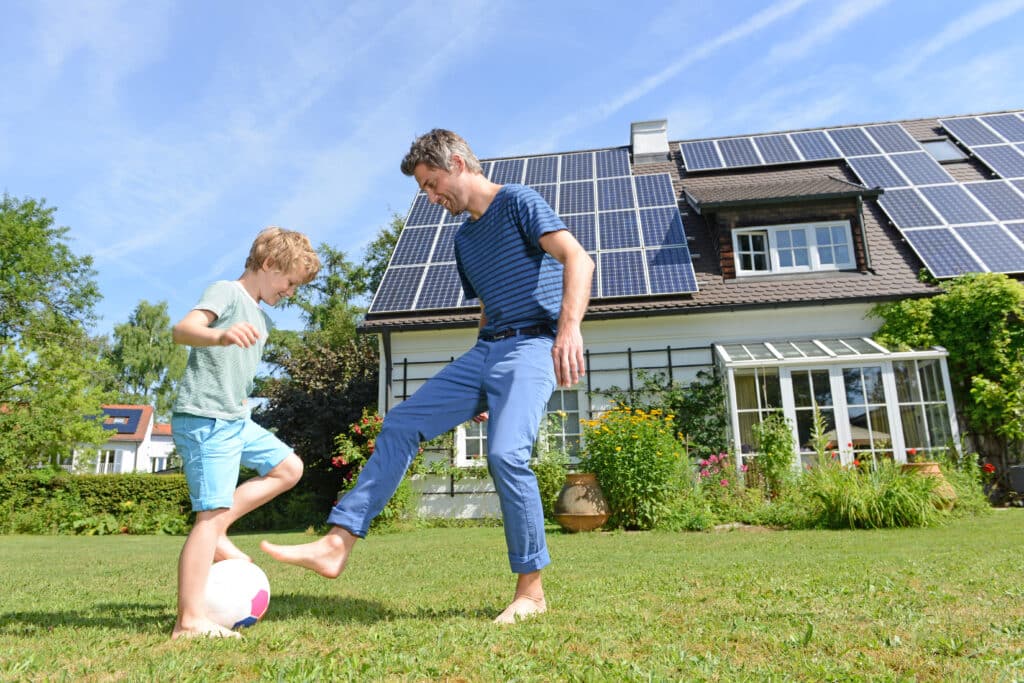 father and son playing in front of affordable solar panels